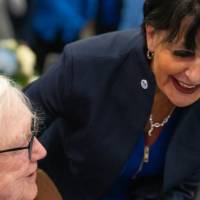 President Mantella leaning over and saying hello to Don Lubbers while he sits at his table